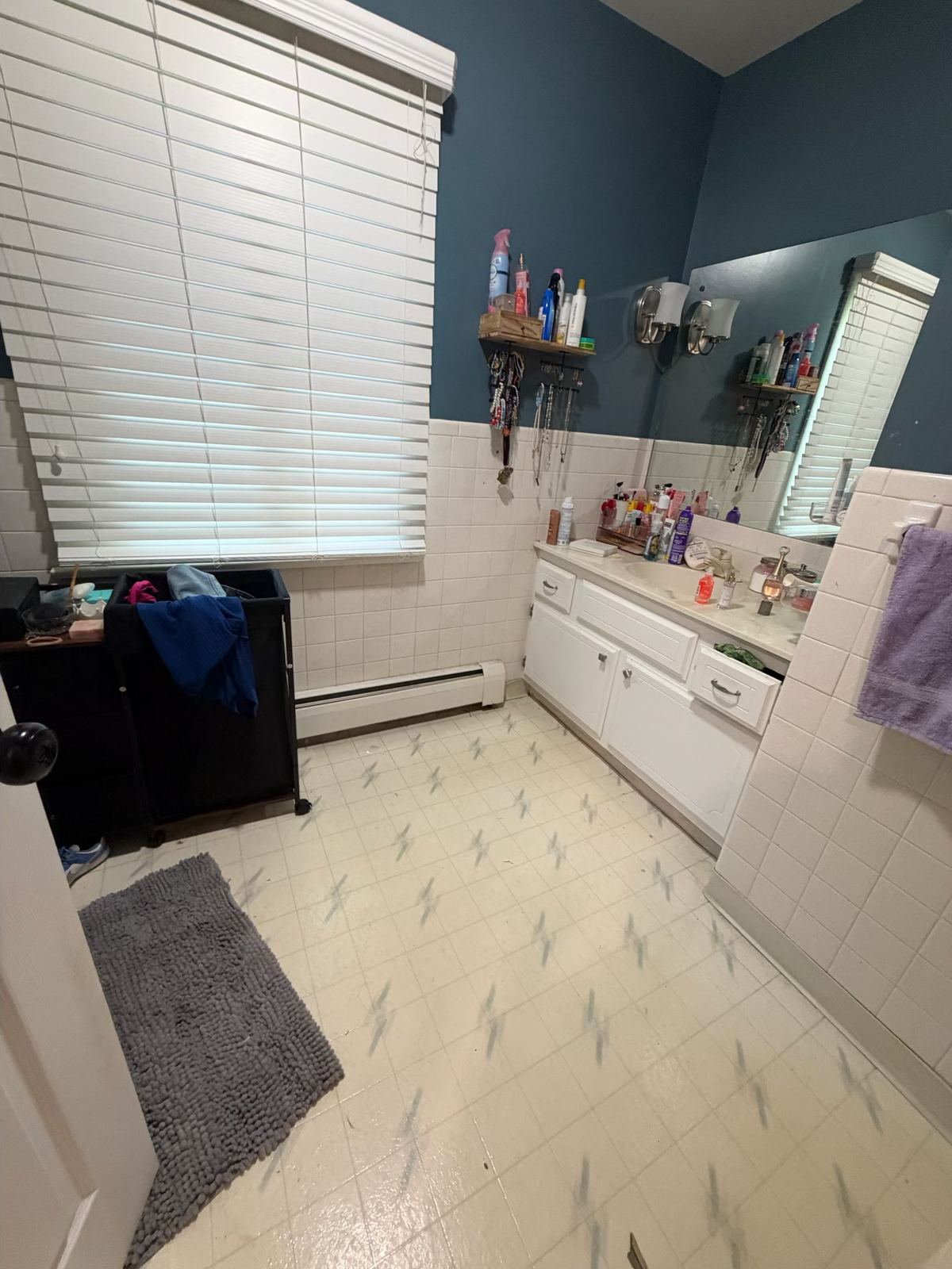 Bathroom with old worn vinyl tile floor before replacement